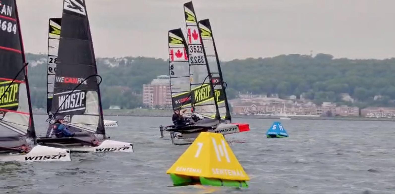 Foiling sailing dinghies racing past Sentenal course marks